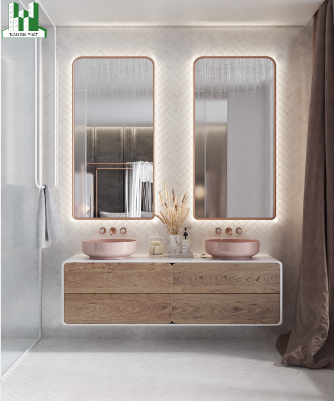 Tiếp tục một mẫu thiết kế phòng tắm với 2 bồn sửa màu hồng và gương được bọc lớp sắt màu hồng xung quanh
