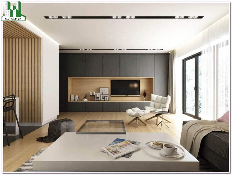 Trong các thiết kế nội thất căn hộ chung cư cao cấp hiện nay, màu xám được nhiều gia đình lựa chọn làm tông màu chủ đạo. Tường nhà màu xám kết hợp sàn nhà ốp gỗ, chiếc bàn màu trắng và hai chiếc ghế sofa đơn màu trắng làm nên vẻ đẹp trung tâm cho căn phòng.