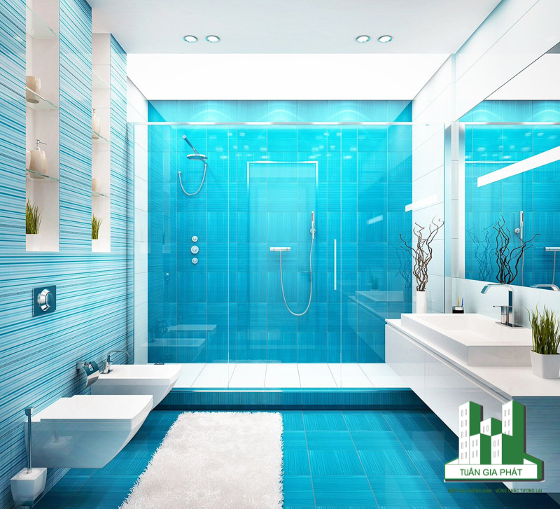 Không gian màu xanh bao trùm, thoáng đãng với khu vực tắm bằng kính. Gia chủ khéo léo tạo điểm nhấn bằng cách bố trí giấy dán tường với các sọc mảnh bên bức tường đối diện với bồn rửa và bàn trang điểm.