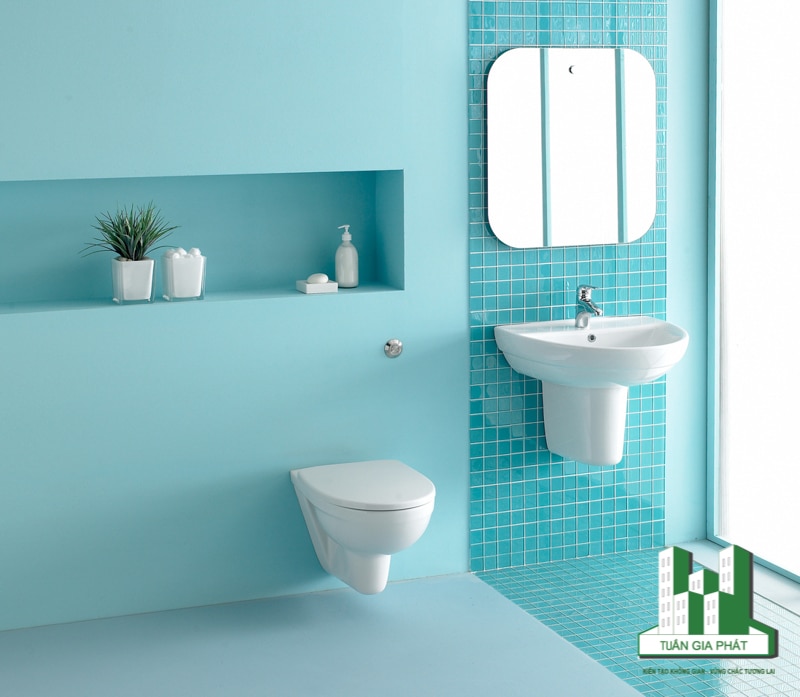 Bức tường sơn màu xanh ngọc lam pastel và sàn nhà có màu tương tự tạo thêm màu sắc tươi mới xung quanh khu vực vệ sinh.