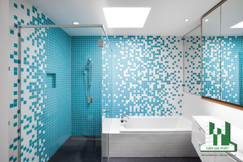 Để tạo điểm nhấn cho bức tường lớn và gạch lát sàn màu xanh trong phòng tắm, bàn trang điểm bằng gỗ màu xanh lam, kệ treo tường nổi là gợi ý. Việc bố trí chứng minh gu thẩm mỹ trong việc sơn, lát gạch của gia chủ.
