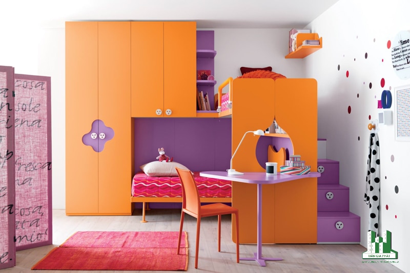 Căn phòng được thiết kế với 2 tông màu cam và tím chắc chắn sẽ khiến các bé thích thú. Giường ngủ được bố trí bên cạnh kệ tủ màu cam và bàn làm việc màu tím giúp bé có không gian riêng. 