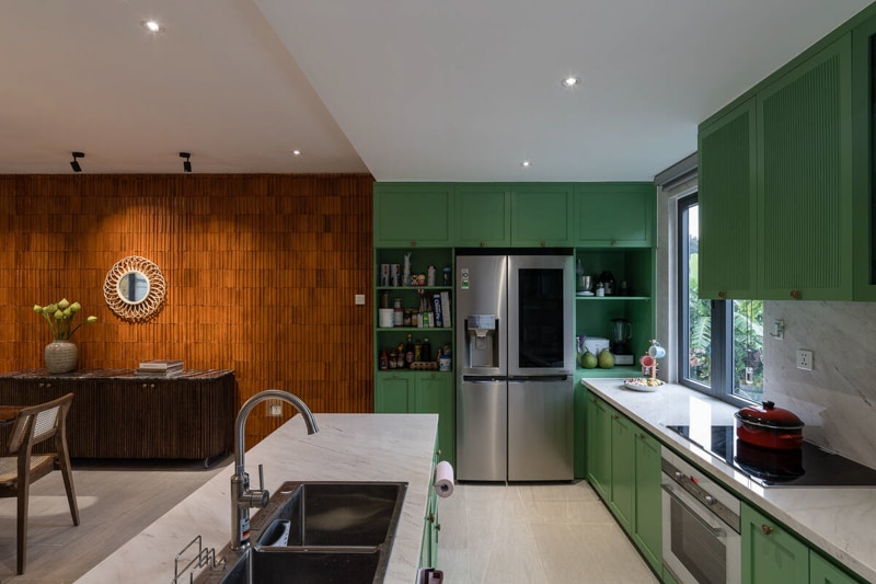 Tủ bếp với sắc xanh mát chủ đạo, hài hòa với không gian căn bếp nhỏ ở tầng dưới